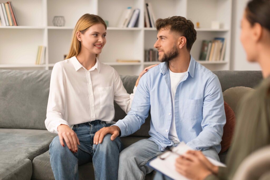 Young couple sits after productive counseling session with psychologist indoors